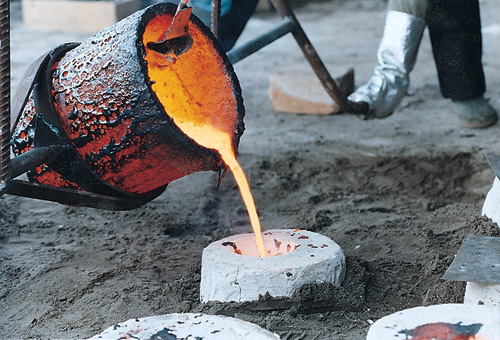 heet brons loopt in de mal in de grond